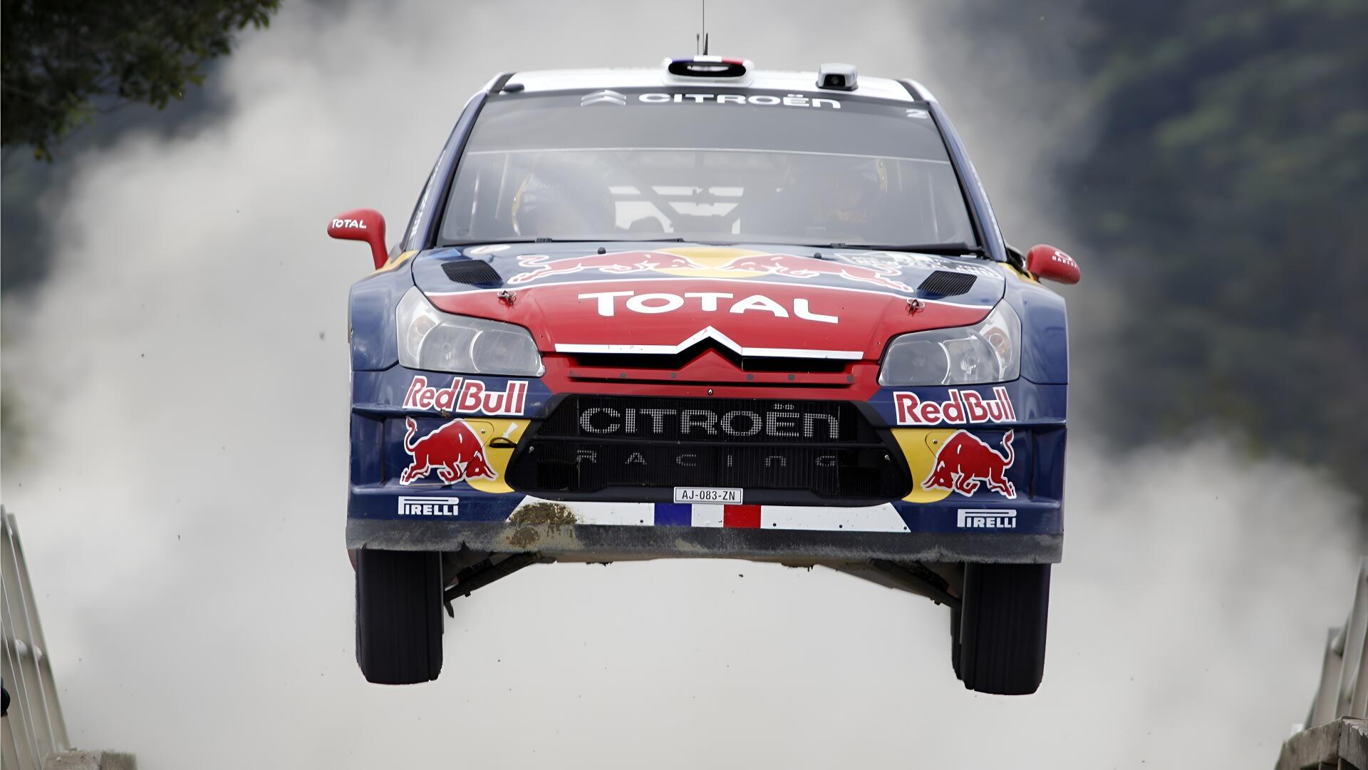 Citroën C4 WRC rally vehicle airborne in Red Bull/Total livery with smoke trail — 4K Ultra HD PC desktop wallpaper/background.