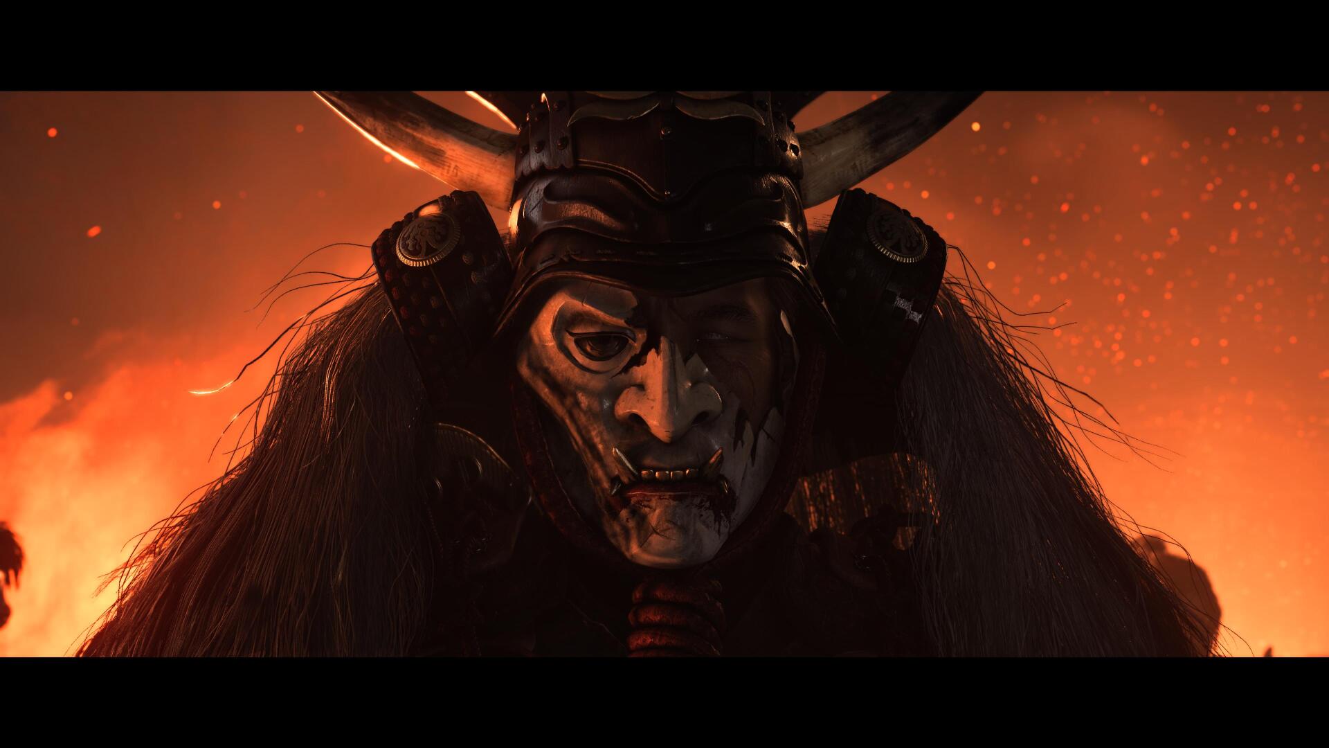 4K Ultra HD PC desktop wallpaper: a horned, masked samurai spirit from the video game Ghost of Yōtei, face half-lit by ember-orange glow with drifting ash.
