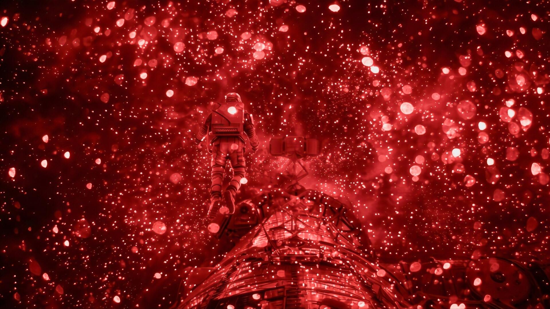 Red HD PC desktop wallpaper showing an astronaut aboard a spacecraft amid sparkling red space — cinematic scene from the movie Project Hail Mary.