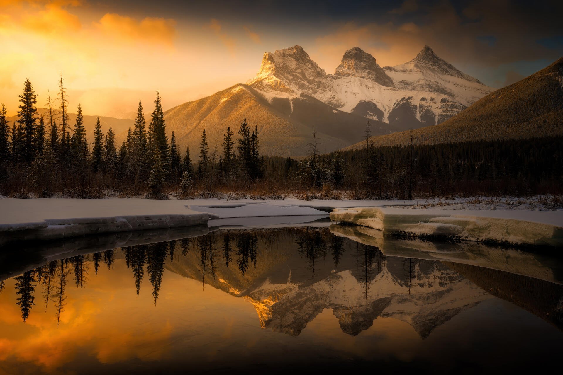 5K Ultra HD PC desktop wallpaper: Golden Hour mountain peaks and pine silhouettes reflected in a glassy alpine lake, snow-capped ridges in a dramatic nature landscape.