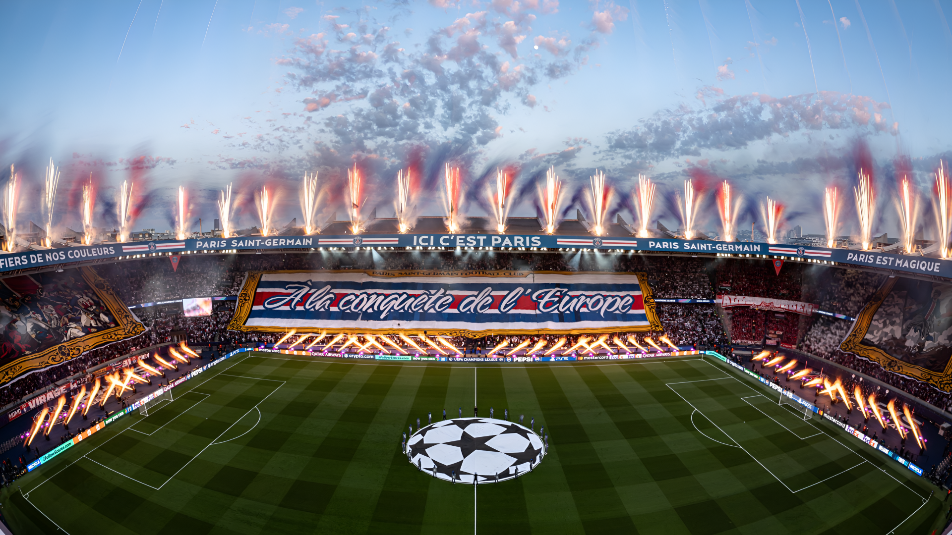 4K Ultra HD PC wallpaper: Paris Saint-Germain stadium aglow for a UEFA Champions League night, pyrotechnics over packed soccer pitch with Champions League emblem.