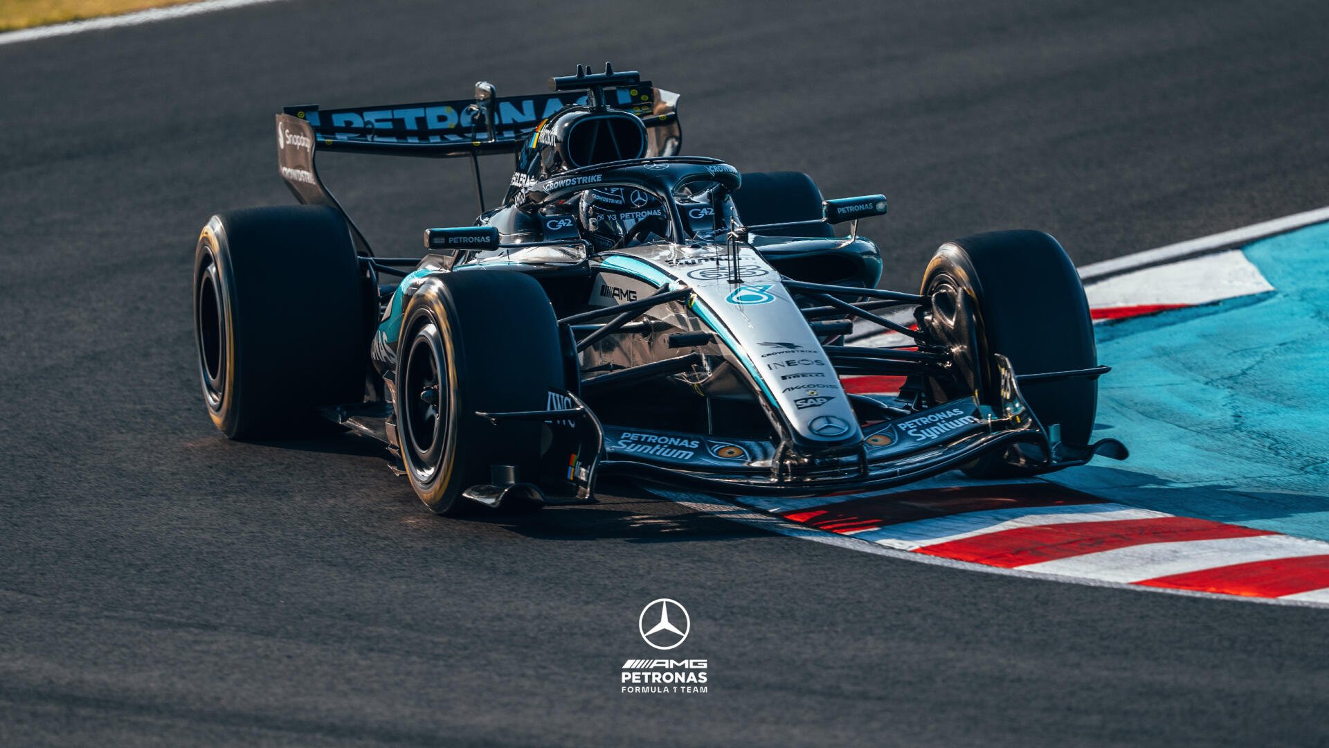 F1 Mercedes-AMG Grand Prix car cornering on track, high-detail 2K Quad HD PC desktop wallpaper and background with Mercedes‑Benz logo at the bottom.