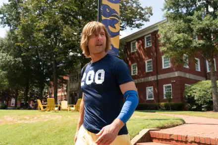 2K Quad HD PC wallpaper featuring TV show character Chad Powers in athletic gear on a sunny college lawn, mid-action with brick dorm and flag visible in the background.