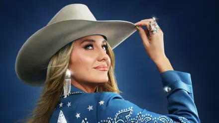 Smiling country singer in a rhinestone blue jacket and cowboy hat, tipping her brim at the CMA Awards — HD PC desktop wallpaper and background.