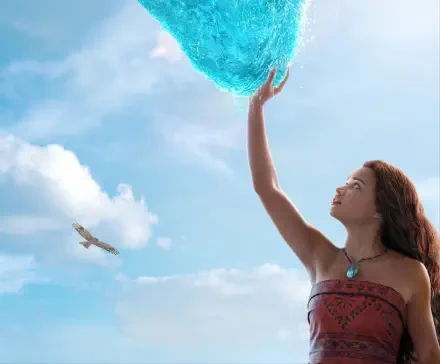 Live-action Moana reaches for a glowing sea orb against a bright blue sky — 2K Quad HD PC desktop wallpaper/background from the movie.