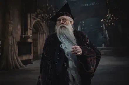 HD PC desktop wallpaper: Albus Dumbledore from the TV show Harry Potter (2027) in robes with a long white beard, standing in a dim, candlelit Great Hall.