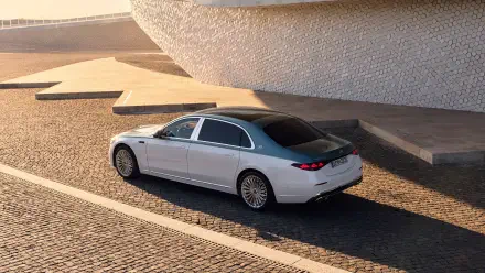 4K Ultra HD PC desktop wallpaper: Mercedes‑Maybach S 680 car in silver, parked on sunlit cobblestone beside modern architectural steps.