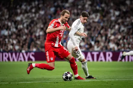 4K Ultra HD PC desktop wallpaper: intense soccer duel with FC Bayern Munich in red and Real Madrid C.F. in white racing across a packed stadium pitch.