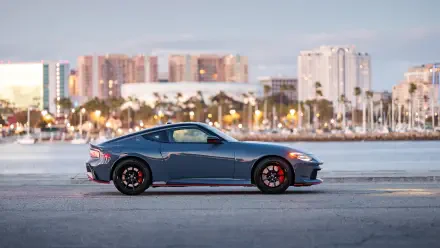 Blue Nissan Z Nismo sports car side profile by a waterfront city — 4K Ultra HD PC desktop wallpaper background.