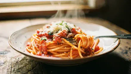 4K Ultra HD PC desktop wallpaper: steaming spaghetti in tomato sauce topped with grated cheese, twirled on a fork over a rustic plate.