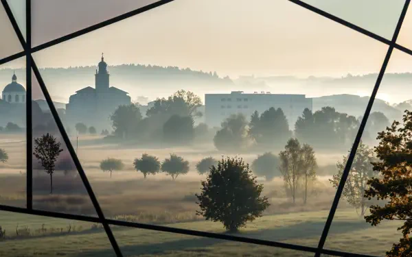 Foggy morning over misty fields and a village silhouette, seen through geometric window lines — 4K Ultra HD PC desktop wallpaper and background.