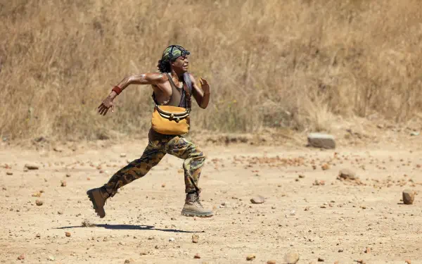 TV show One Piece (Live Action) wallpaper: Usopp sprints across a dusty plain in a 2K Quad HD PC desktop background.