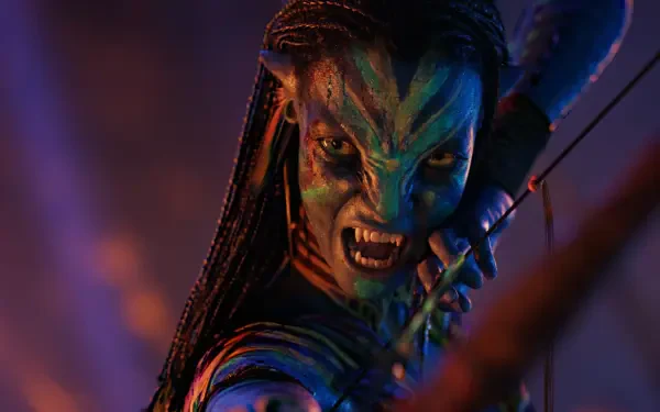 Snarling Na'vi warrior drawing a bow, braided hair and glowing blue skin under fiery orange and purple light — Avatar: Fire and Ash 4K Ultra HD PC Desktop Wallpaper and Background.