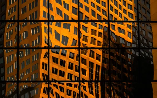 4K Ultra HD PC desktop wallpaper and background photography: orange building facade reflected in grid of window panes, forming an abstract architecture pattern.