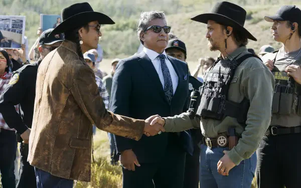 TV show marshals: two men in cowboy hats shake hands as tactical marshals and a suited official watch — 2K Quad HD PC desktop wallpaper/background.