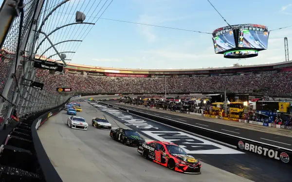 NASCAR stock cars racing around Bristol Speedway’s oval with packed stands, high-speed sports race action — 2K Quad HD PC desktop wallpaper and background.