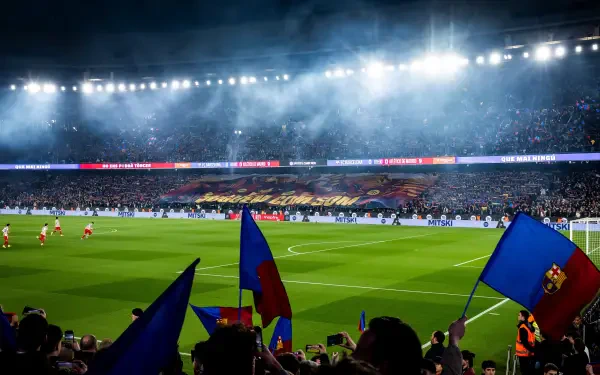 4K Ultra HD PC desktop wallpaper showing a night match at Camp Nou: a lit soccer field in a packed stadium with FC Barcelona fans waving blue-and-red flags.