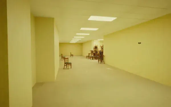 Backrooms 4K Ultra HD PC desktop wallpaper and background — long empty yellow corridor lit by fluorescent panels, scattered chairs and shelving, eerie sterile atmosphere.