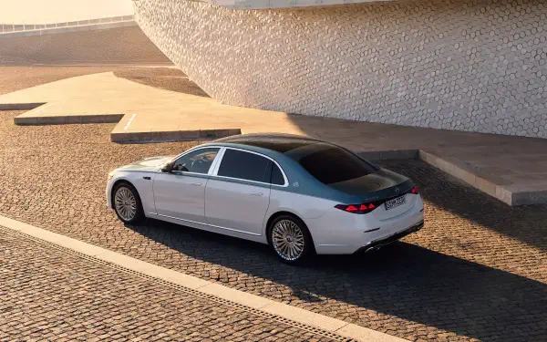 4K Ultra HD PC desktop wallpaper: Mercedes‑Maybach S 680 car in silver, parked on sunlit cobblestone beside modern architectural steps.