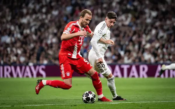 4K Ultra HD PC desktop wallpaper: intense soccer duel with FC Bayern Munich in red and Real Madrid C.F. in white racing across a packed stadium pitch.