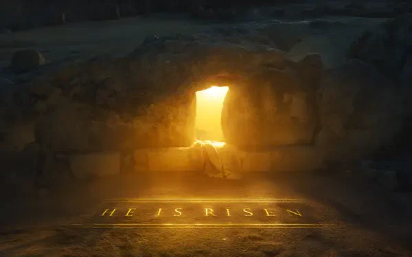 2K Quad HD desktop wallpaper: empty tomb with stone rolled away, golden light pouring through the entrance and HE IS RISEN glowing on the floor, evoking Jesus' resurrection.