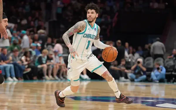 NBA action: Charlotte Hornets guard in teal-and-white uniform dribbling past a defender on the court — dynamic 2K Quad HD PC desktop wallpaper.