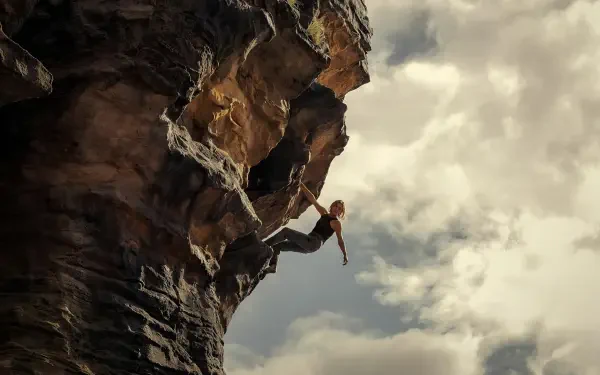 4K Ultra HD PC desktop wallpaper/background from the movie Apex (2026): lone climber hangs from a sheer rock face against dramatic cloudy skies.