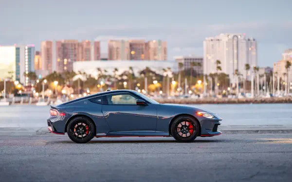 Blue Nissan Z Nismo sports car side profile by a waterfront city — 4K Ultra HD PC desktop wallpaper background.