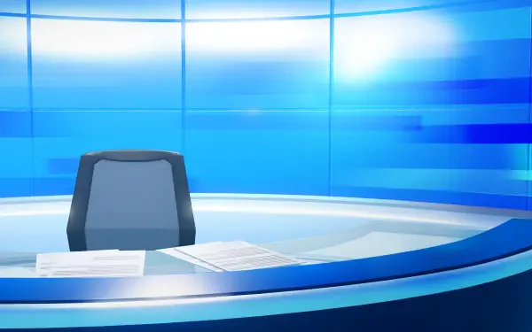 Tomodachi Life: Living the Dream HD PC desktop wallpaper showing a sleek blue broadcast desk with an empty chair and scattered papers in a bright, futuristic studio.