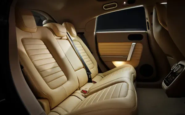 4K Ultra HD PC desktop wallpaper of a Ferrari Luce vehicle interior — plush beige rear leather seats, seatbelts, door panel and warm ambient lighting.