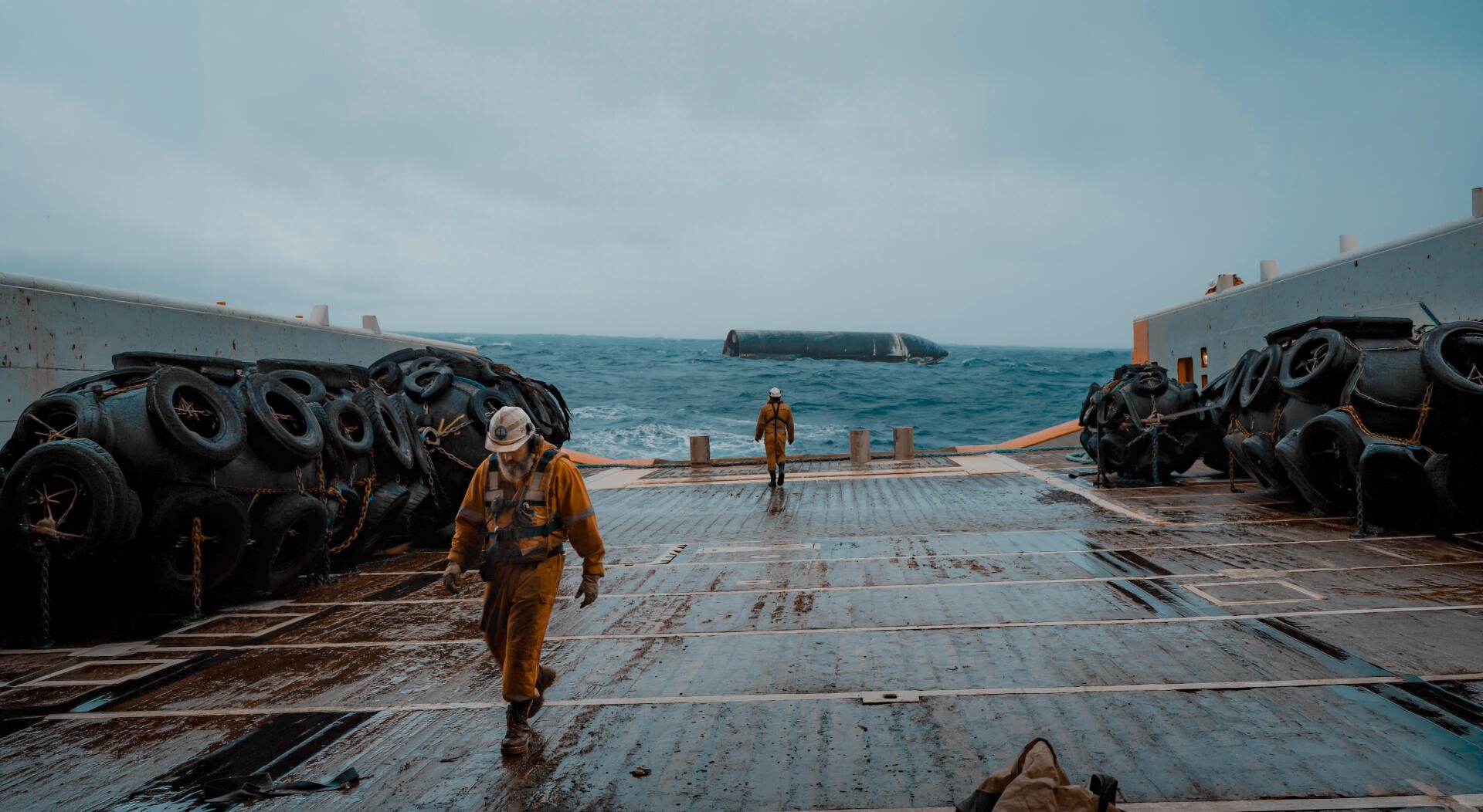 5K Ultra HD PC desktop wallpaper: men in yellow suits on a ship deck, ocean ahead and a SpaceX Starship resting on the water.