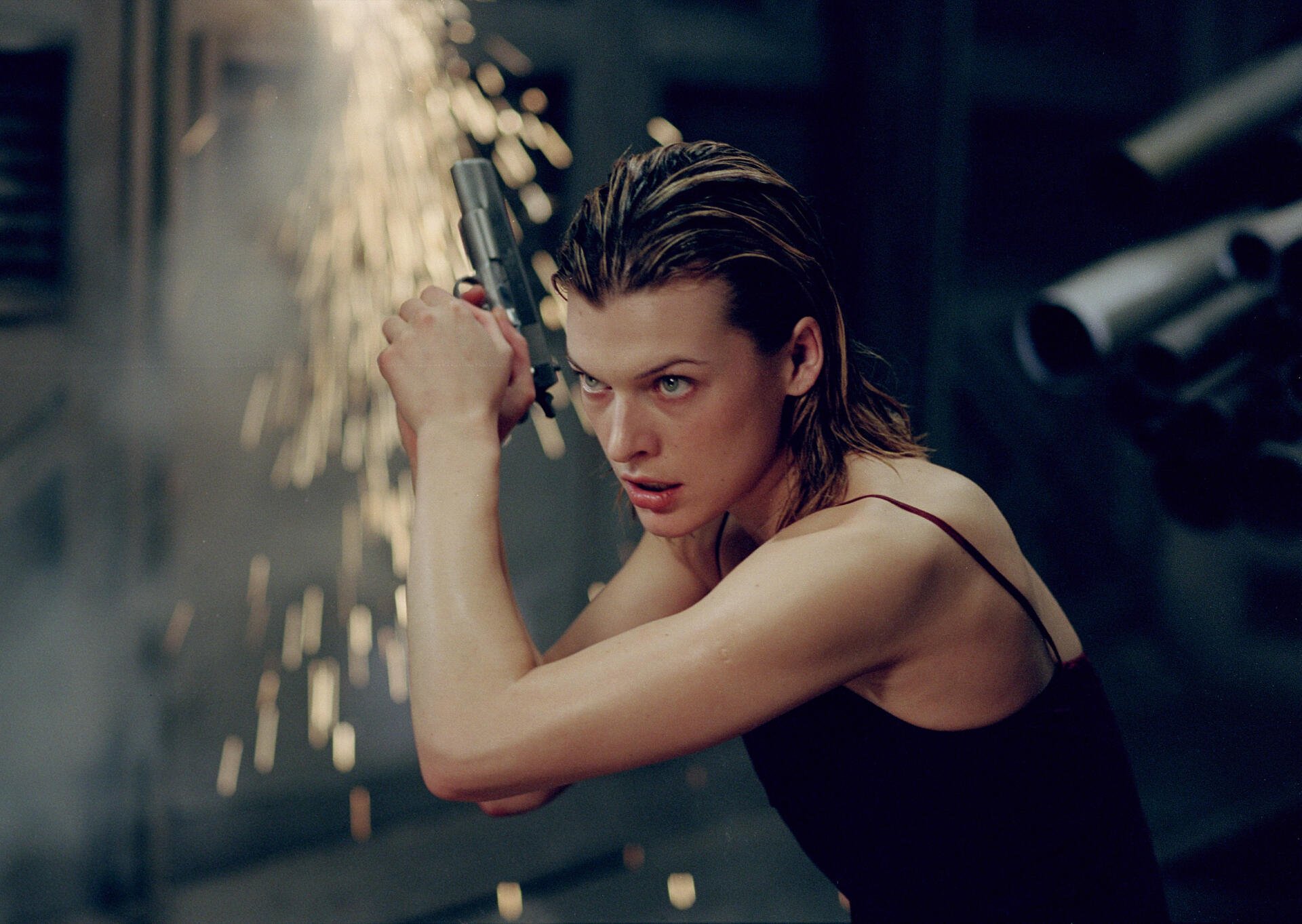 2K Quad HD PC wallpaper: Resident Evil–style action shot of a determined woman in a black tank top swinging a handgun amid sparks in a dim industrial corridor.