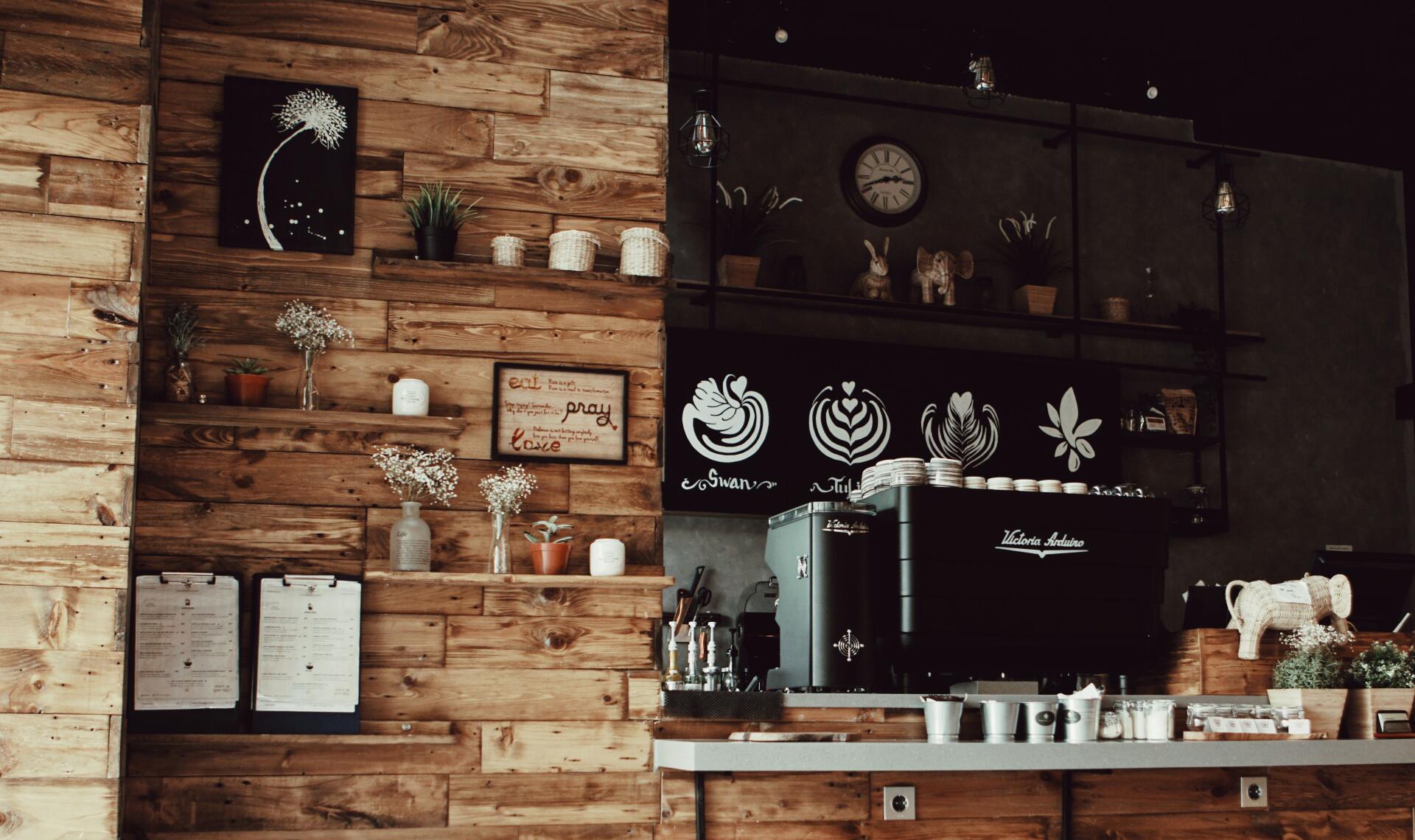 Espresso Fall Cozy 5K Ultra HD PC desktop wallpaper: warm rustic coffee bar with espresso machine, wooden shelves, cups, plants and autumnal decor.