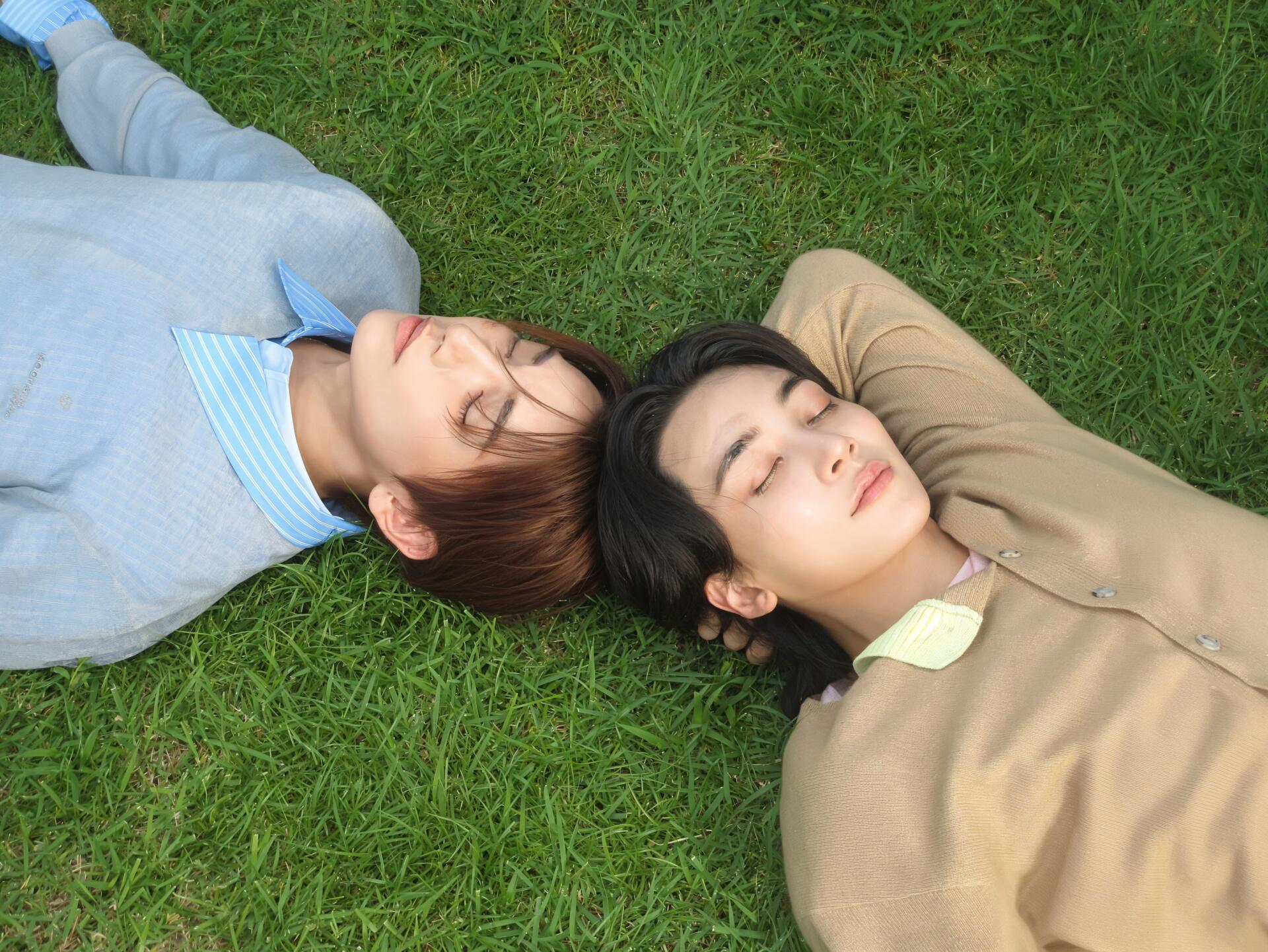 Seventeen’s Jeonghan and Joshua Hong lying on grass, captured in a 4K Ultra HD PC desktop wallpaper and background.