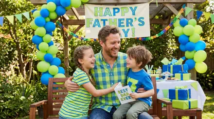 5K Ultra HD PC desktop wallpaper and background: smiling father sits outdoors with two children hugging under a 'Happy Father's Day' banner, surrounded by balloons and wrapped gifts.