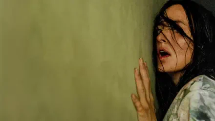 Backrooms 4K Ultra HD PC desktop wallpaper and background: woman with wet dark hair pressed to a grimy yellow wall, hand splayed, eyes wide in a dim, claustrophobic corridor.