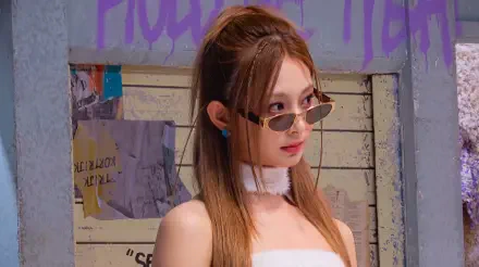 5K Ultra HD desktop wallpaper: young woman in slim shades, white tube top and choker, long brown hair and blue studs, posing in front of a graffiti-covered wall.