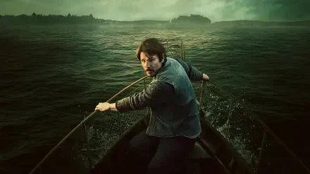 Below 2K Quad HD PC desktop wallpaper featuring a man rowing through dark waters beneath misty green mountains.