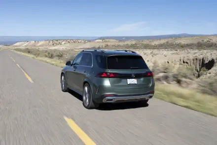 Mercedes-Benz GLS SUV driving along a scenic desert road, featured in an HD PC desktop wallpaper and background.