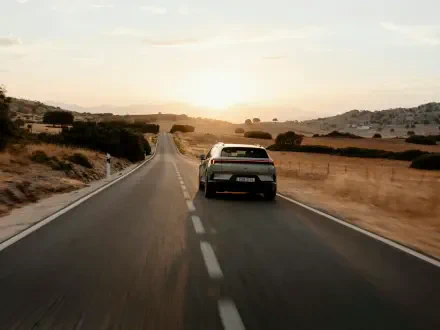 Polestar 4 SUV driving along a winding country road at sunset, featured in a 5K Ultra HD PC desktop wallpaper.