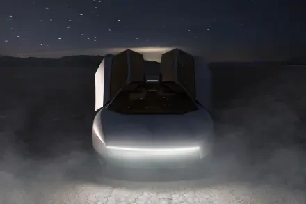 Futuristic Tesla Roadster with glowing headlights in a dark, misty scene, featured in a 2K Quad HD PC desktop wallpaper background.