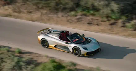 5K Ultra HD desktop wallpaper featuring an Aston Martin Valhalla Spider convertible sports car speeding along a scenic road.