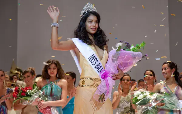 4K Ultra HD PC desktop wallpaper: beauty pageant winner on stage with tiara and sash reading Miss Bala, holding a bouquet as confetti falls around her.