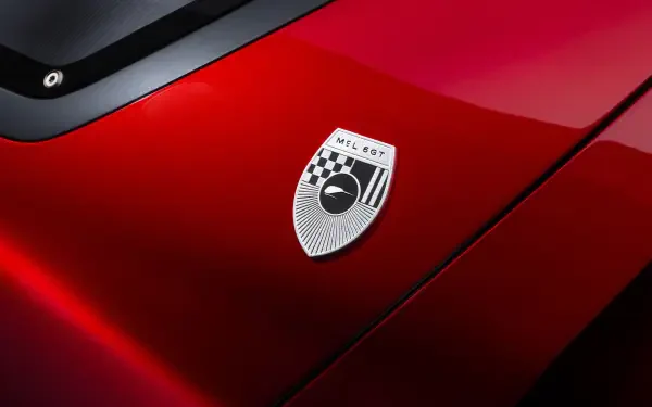Close-up of a red McLaren McL 6GT hood and badge with high-gloss finish; 5K Ultra HD PC desktop wallpaper background.