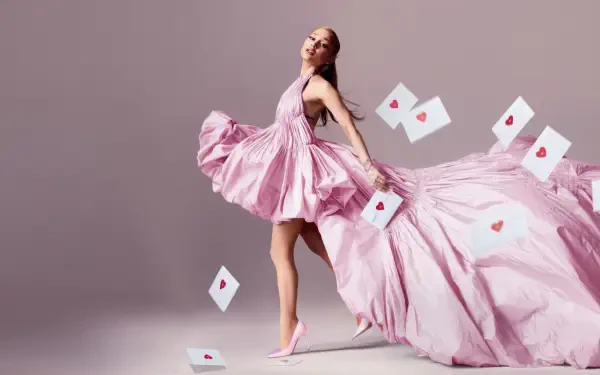 Woman in a flowing pink gown and heels, playing-card hearts drifting around her as she strikes a graceful pose — 4K Ultra HD PC desktop wallpaper.