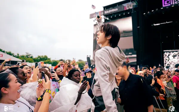 Singer leaning into an ecstatic festival crowd at the Cortis concert, hands raised and phones out, vibrant 4K Ultra HD PC desktop wallpaper and background.