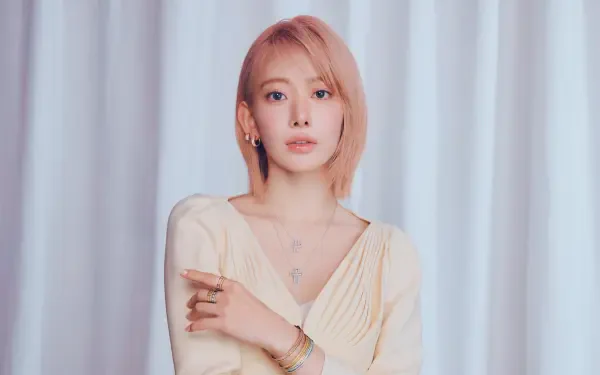 5K Ultra HD desktop wallpaper: portrait of a pink‑haired young woman in a cream outfit standing before soft pale curtains, minimal makeup and a calm, poised expression.