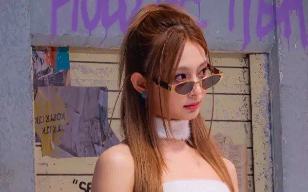5K Ultra HD desktop wallpaper: young woman in slim shades, white tube top and choker, long brown hair and blue studs, posing in front of a graffiti-covered wall.