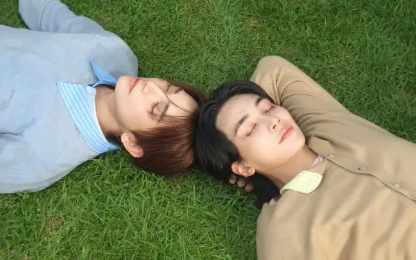 Seventeen’s Jeonghan and Joshua Hong lying on grass, captured in a 4K Ultra HD PC desktop wallpaper and background.