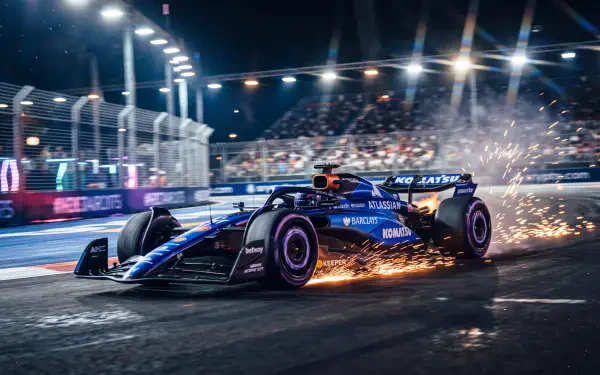 Williams FW48 F1 race car speeding through a floodlit night circuit, sparks flying, in a 5K Ultra HD PC desktop wallpaper.